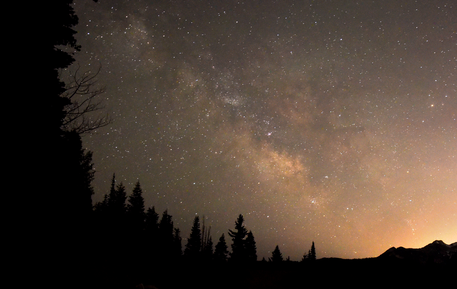 Milky way visible among thousands of stars above a mountain outline