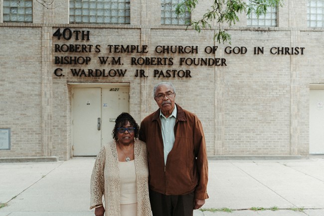 Two people standing in front of a church