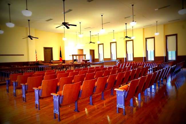 Empty seats line the interior of a courtroom.