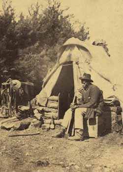 Image of man sitting outside of tent in contraband camp
