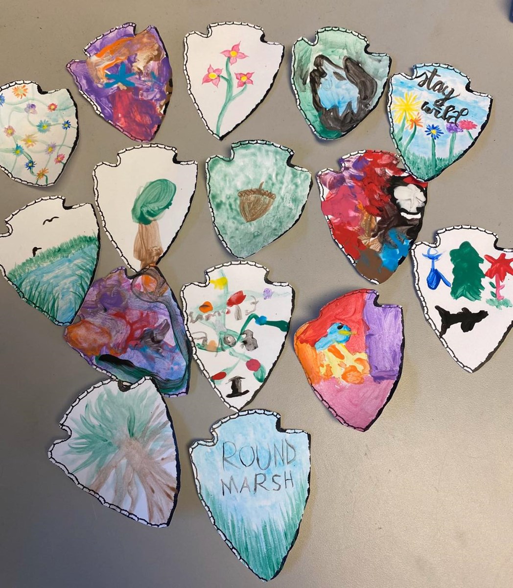 a variety of nature painting in an arrowhead shape done by kids