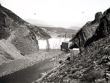 Black and white image of Roosevelt Dam in 1909. Image taken from down steam looking up with salt river canyon on both sides.