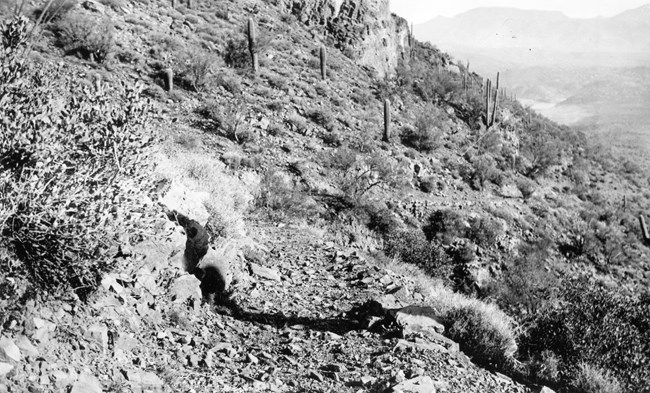 A black and white photo of the original rocky trail. Lake Roosevelt in the background.