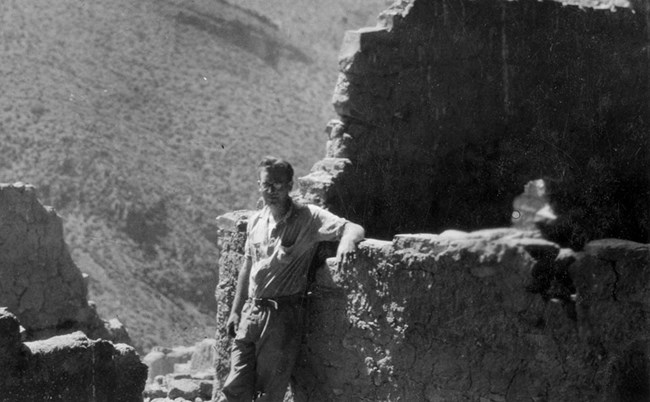 Man leaning on ancient cliff dwelling wall