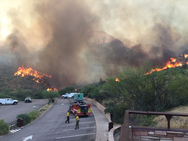 Hills burning with firefighters in foreground