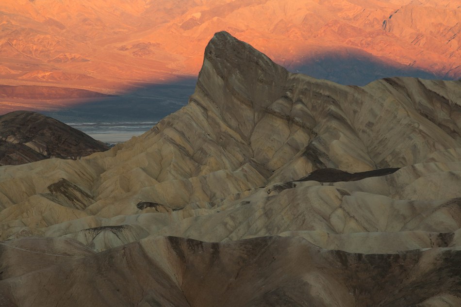 Eroded badland hills in the morning sunrise with a prominent point. Eroded badland hills in the morning sunrise with a prominent point.