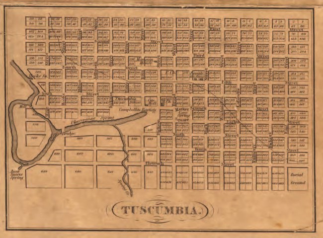 A historic map of grid sections with a railroad route running through the lower left corner.