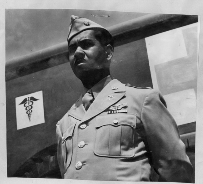 Vance Marchbanks stading in uniform next to a Red Cross symbol