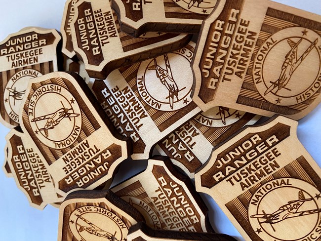A pile of wooden Junior Ranger badges