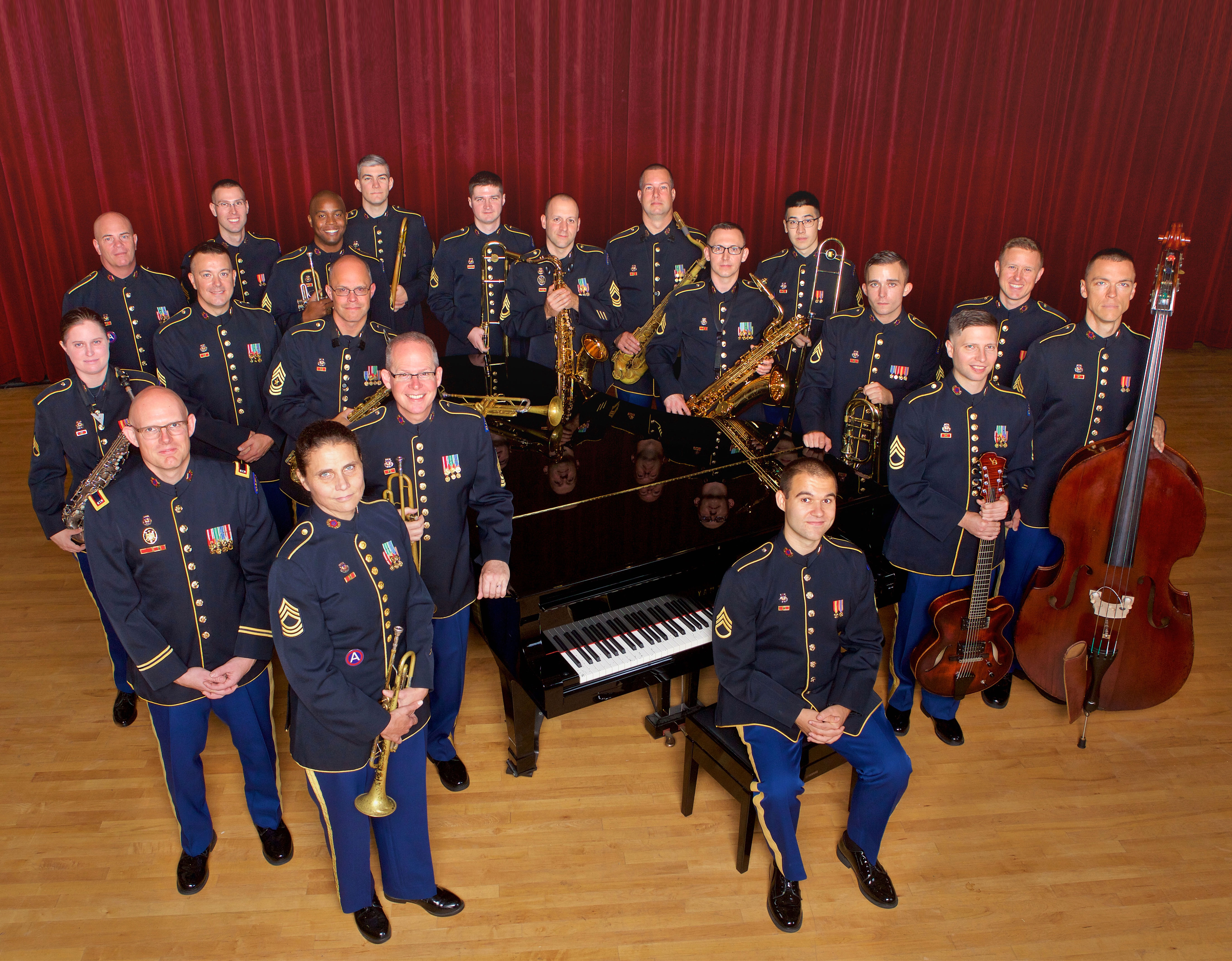 Colored photo Jazz members in full uniform standing around piano holding jazz instruments