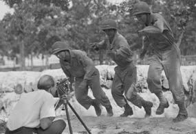 Photographer Tom Parker shooting film footage of Japanese American Soldiers in action at Camp Shelby.
WRA Photograph by Charles Mace - 1943