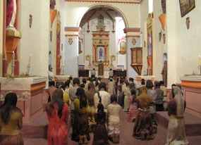 diorama of people kneeling in church nave