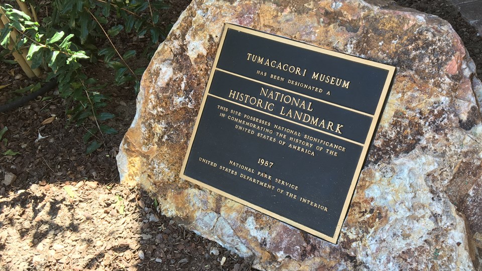 national historic landmark designation plaque set in large boulder