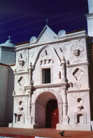 white-washed facade of highly-decorated adobe church