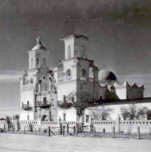 historic black and white photo of ornate white church with tall bell towers and dome