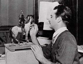 historic photo of man painting horse model