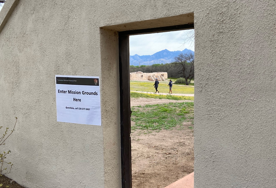 Tumacácori remains open to dispersed outdoor activities. open side gate, people walking