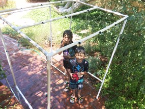 kids in sprinkler, smiling and laughing
