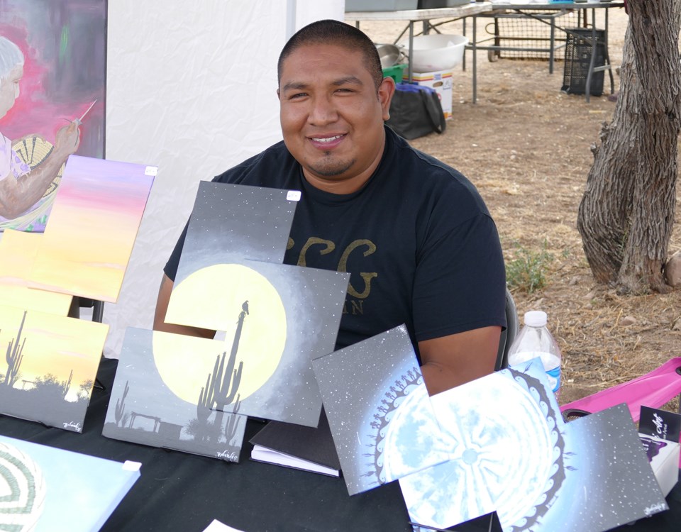 artist with painted panels in front of him