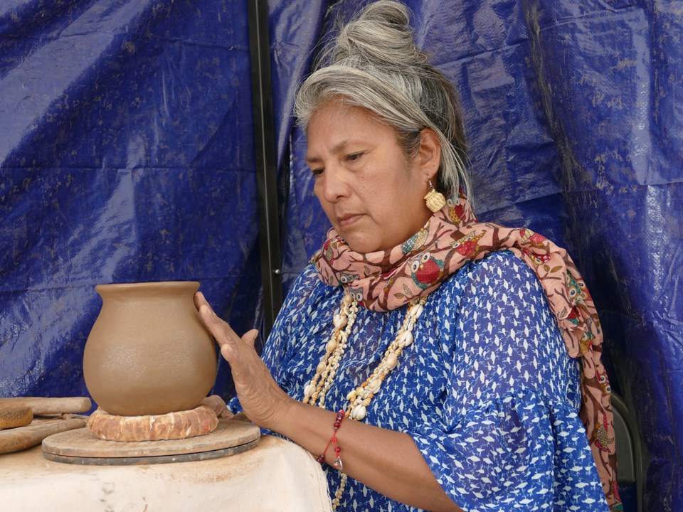 Demonstrator working on ceramic pottery.