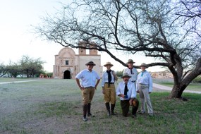 rangers in historic uniforms stand in front of the mission church