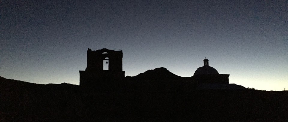 silouette of bell tower, dome, and mountain against night sky