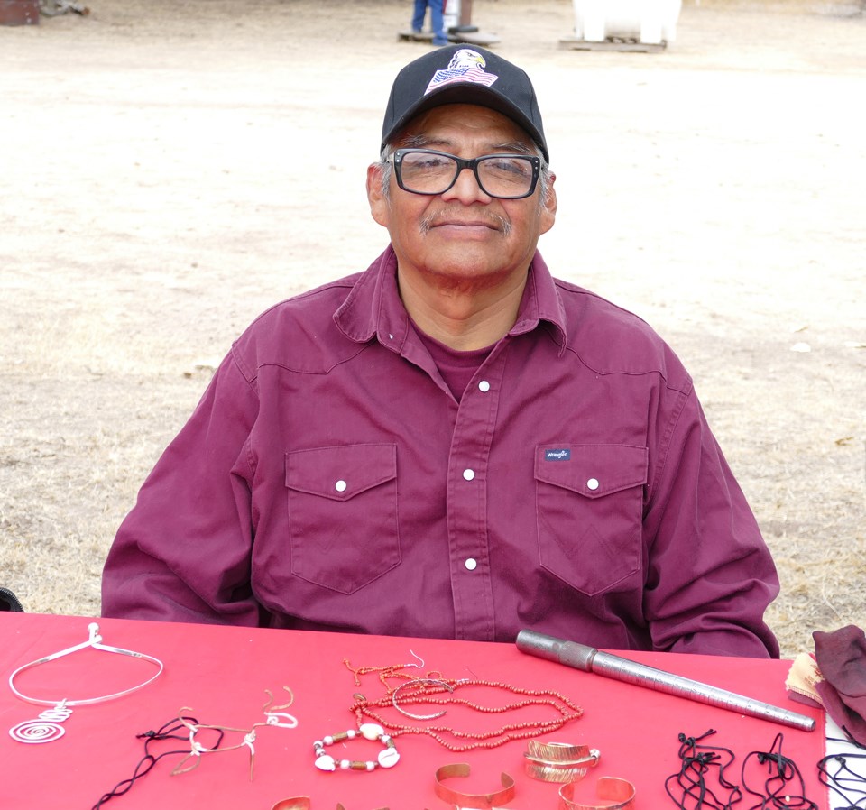 Demonstrator with wire basketry materials and tools.