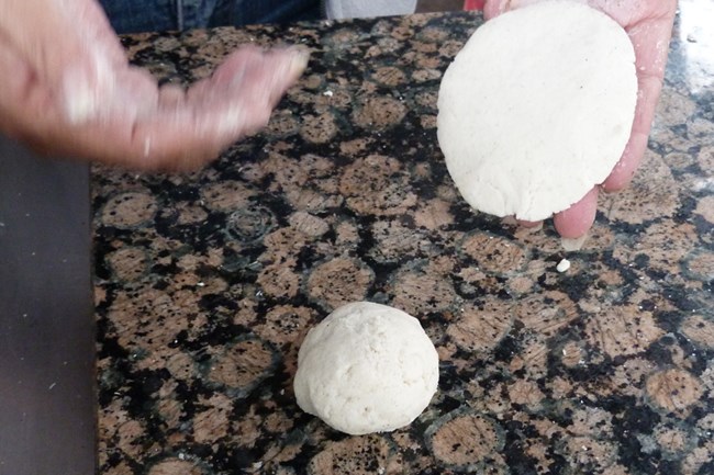 Closeup of corn masa ball with flattened tortilla.