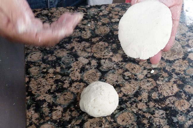 Closeup of corn masa ball with flattened tortilla.