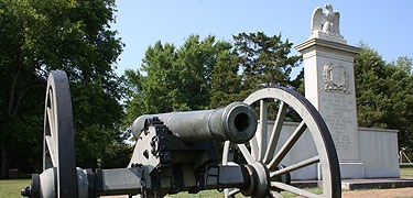 Granite monument commemorating the soldiers who fought at the Battle of Tupelo also known as the Battle of Harrisburg. A granite eagle sits on the top of the monument. A cannon sits in front of the monument