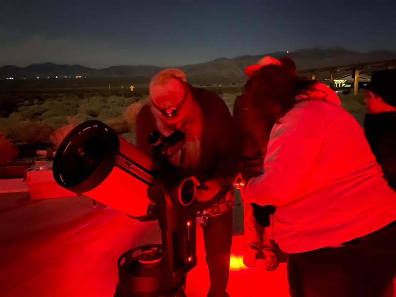 National Park Service volunteer and park visitors look through a telescope at various planets during the first Night Sky program for Tule Springs Fossil Beds National Monument. National Park Service volunteer and park visitors look through a telescope at various planets during the first Night Sky program for Tule Springs Fossil Beds National Monument.
