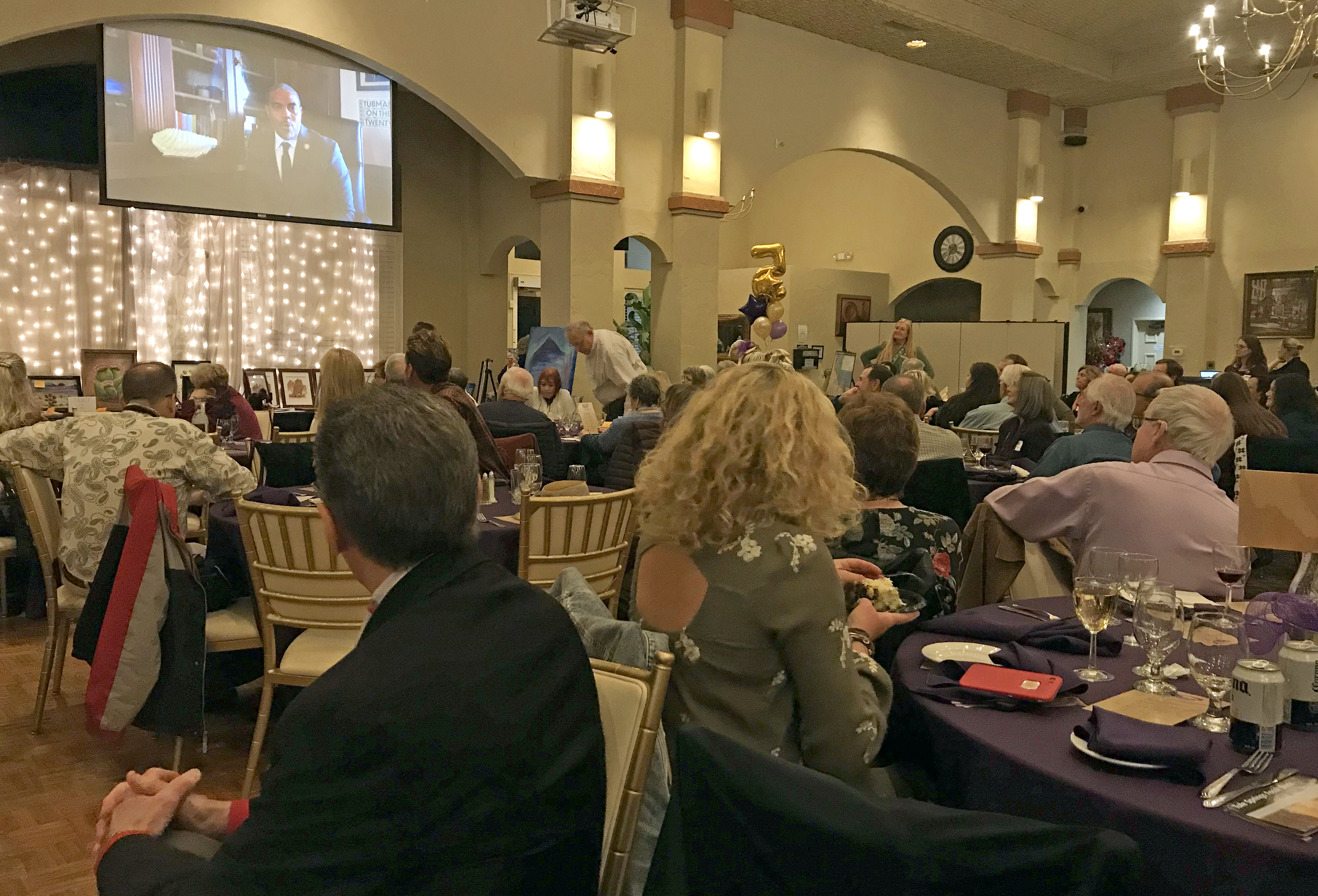 event goers watch U.S. Rep. Horsford on video