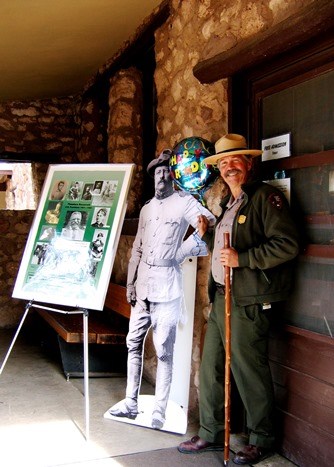 Ranger John Reid in uniform celebrating President Roosevelt's birthday in 2006, with a balloon and life-size cut out of Theodore Roosevelt.
