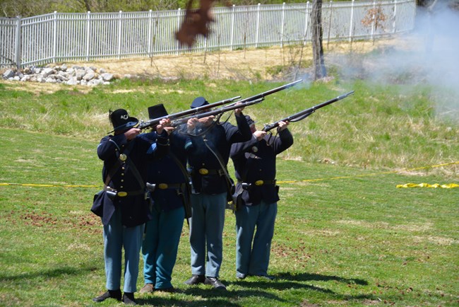 Reenactors demonstrate historic muskets