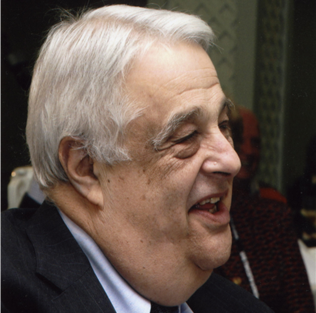 Older man smiling and wearing a dark suit