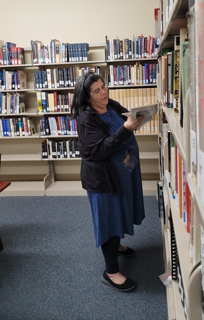 woman in library holding book