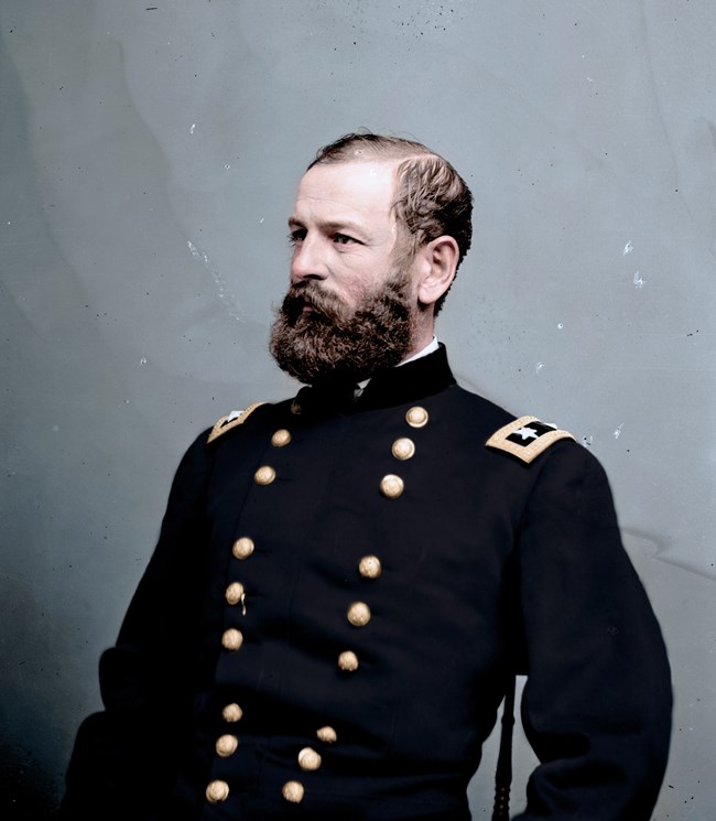 Man with short brown hair and a beard wearing a dark blue Civil War Union uniform with brass buttons.