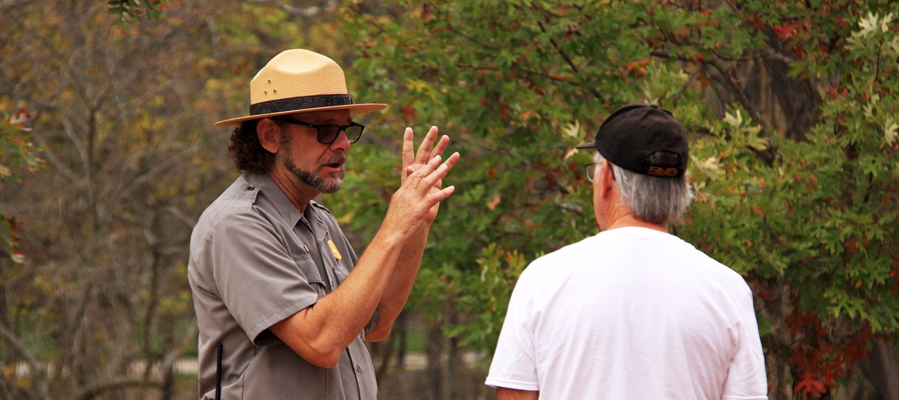Photo of a Ranger and adult visitor in conversation