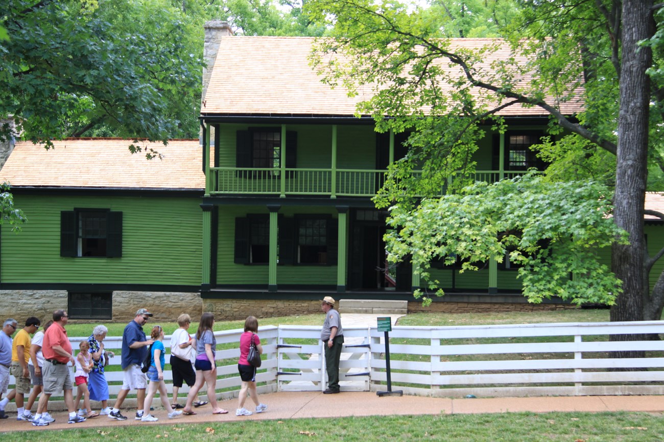 Photograph of a National Park Service ranger leading a tour in front of White Haven