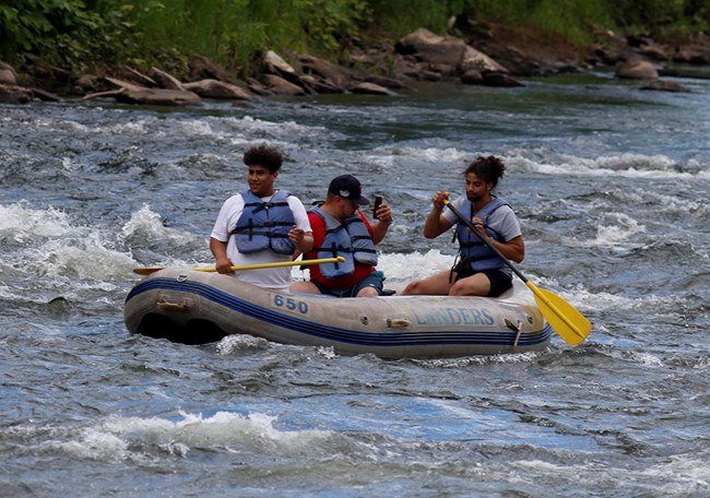 Tres kayakistas reman en el rio
