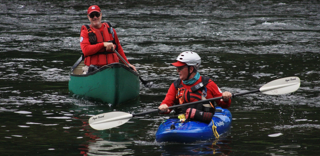 ncsp_volunteer_skinnersfalls edited two national canoe safety patrol volunteers paddle in kayaks on water
