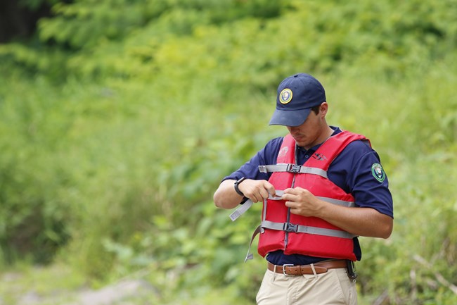 Intern putting on his red life jacket.