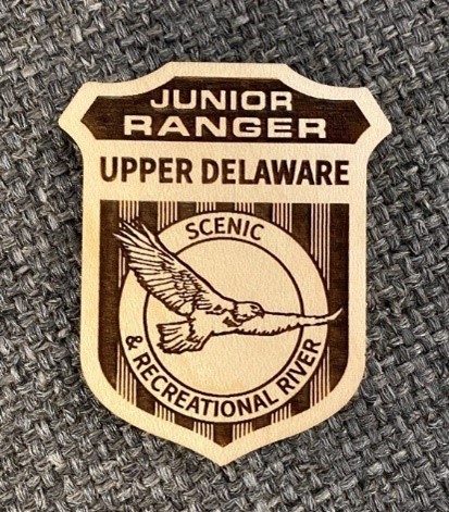 Upper Delaware's new wooden Junior Ranger badge with an image of a bald eagle. Upper Delaware's new wooden Junior Ranger badge with an image of a bald eagle.