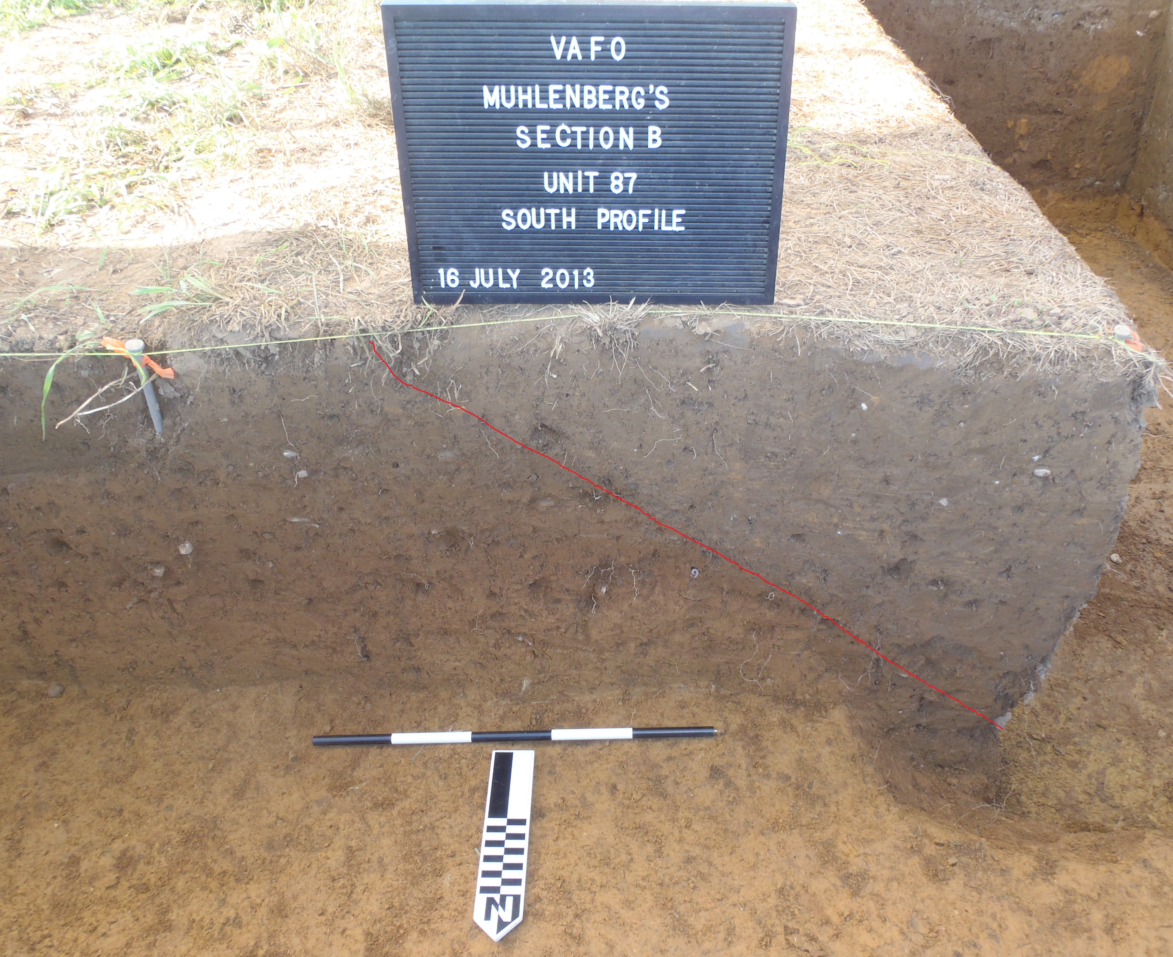 Profile view of the pit. The red line roughly delineates the pit from the natural soil. Note how the pit cuts through the levels of the soil. Also, note the mottled soil Profile view of the pit. The red line roughly delineates the pit from the natural soil. Note how the pit cuts through the levels of the soil. Also, note the mottled soil