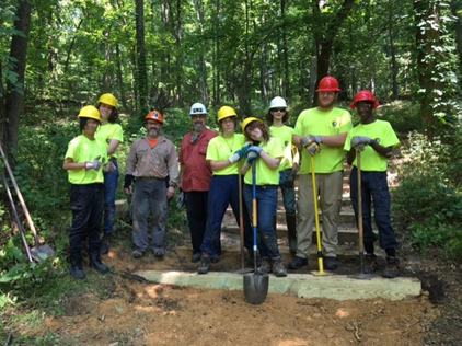 YCC on Mount Misery photograph, Nine smiling people wearing hard hats hold shovels and wear gloves