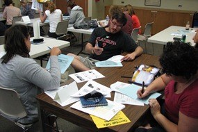 Teachers working in a group around a table with primary source documents and notes Teachers working in a group around a table with primary source documents and notes
