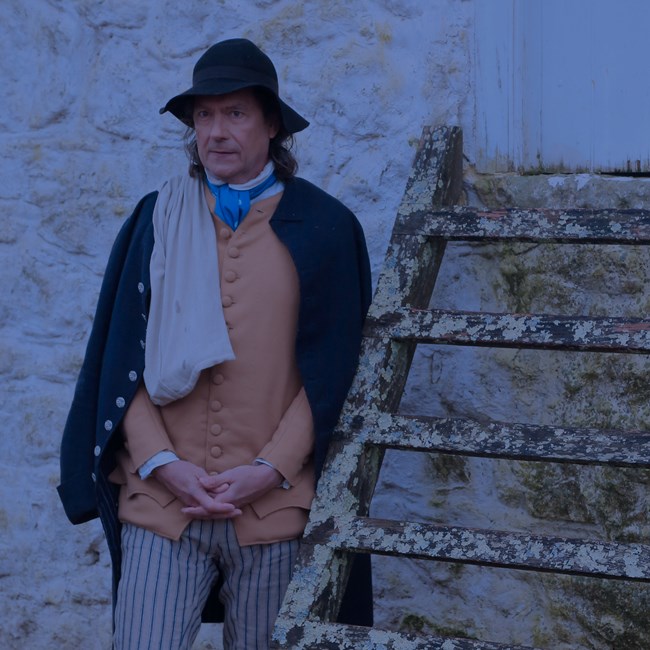 outdoors, stone wall, man, frown