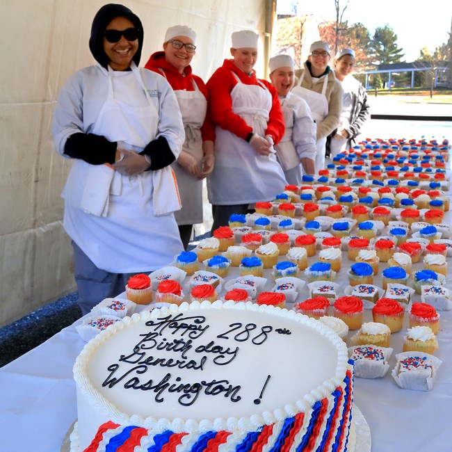 outdoors, tent, cupcakes, cake, table, smiling faces