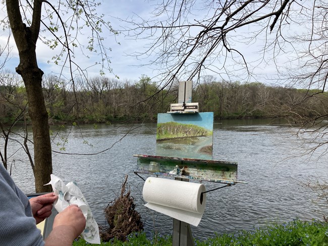 a painting of a river sits on an easel