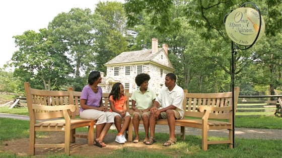 A Storyteller provides a program to a family outside of Washington's Headquarters A Storyteller provides a program to a family outside of Washington's Headquarters